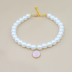 Detail of pet pearl necklace with pink rose enamel pendant and lobster clasp closure