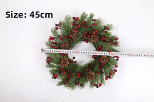 Detail of a 45cm Christmas wreath with green pine needles, red berries, and pine cones
