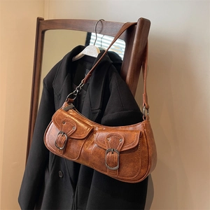 Vintage brown PU leather crescent shoulder bag with belt buckle pockets on black coat