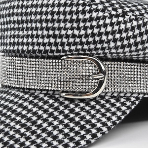 Chic black and white houndstooth newsboy cap with sparkling rhinestone band and silver buckle