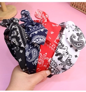 Detailed close-up of a 4-piece paisley knotted headband set in black, navy, red, and white
