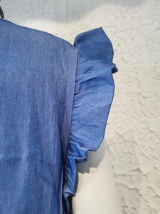 Detailed view of the ruffle sleeve on a casual blue denim dress with soft fabric texture