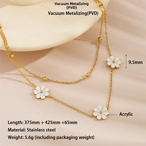 Détail du collier double rang en acier doré PVD avec des marguerites en acrylique