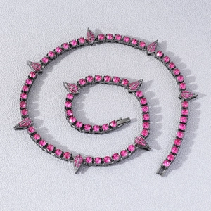 Pink rhinestone tennis necklace with sharp spikes in hip hop style on grey background