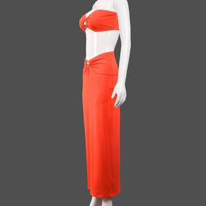 Detail of orange knit crop top with a metallic center ring and matching high waist skirt