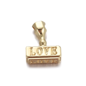Macro detail of 18K gold plated seal pendant with embossed LOVE text on base