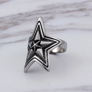 Macro shot of retro stainless steel star ring with oxidized vintage texture and polished edges