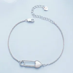 S925 sterling silver heart bracelet with cubic zirconia safety pin link on blue background