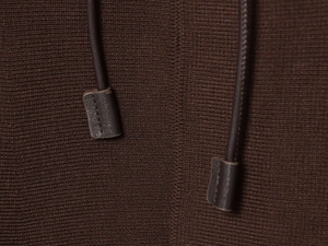 Detail of brown knit fabric with drawstring and decorative leather cord end caps