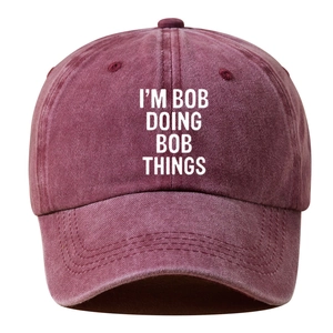 Detail of burgundy washed cotton baseball cap with I'M BOB DOING BOB THINGS text