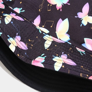 Detail view of colorful butterfly and music note prints on a black bucket hat