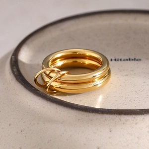 Macro view of 18k gold plated stainless steel stacked rings with two small loop charms