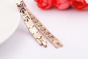 Nahaufnahme des roségoldenen Edelstahl-Magnetarmbands mit schwarzen Einlegesteinen