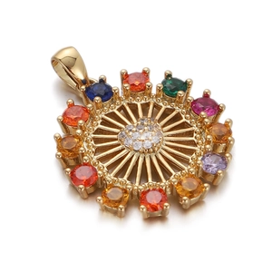 Macro view of gold plated sunburst pendant with colorful gemstones and clear zircon center