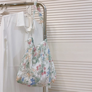 Detalle del bolso hobo de lona con estampado floral vintage y correa ancha