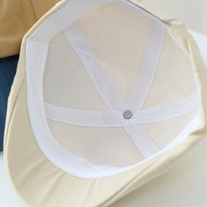 Close-up of beige beret hat interior with sweatband, reinforced stitching and mesh liner