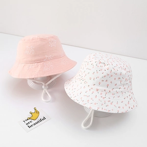 Detail of baby cotton sun hats with pink star and polka dot patterns and chin straps