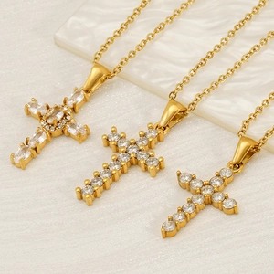 Macro shot of gold-plated cross necklaces with round zircon stones and intricate details