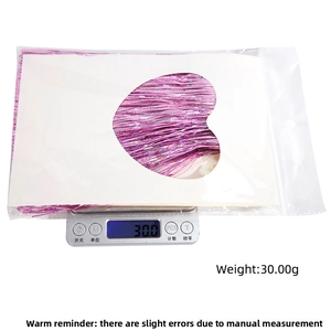 Detailed view of pink foil fringe curtain package weighing 30.00g on a digital scale