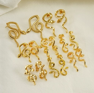 Flat lay of multiple 18K gold plated stainless steel snake earrings with scale textures