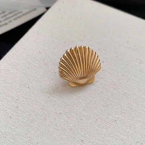 Detailed macro shot of golden seashell ear cuff featuring fine radial texture and polish