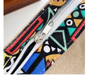 Detailed close-up of a tribal geometric woven canvas bag featuring a sturdy metal zipper