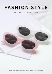 Detail of trendy small cat eye sunglasses in pink and white on a minimalist white base
