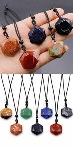 Macro detail of geometric faceted natural crystal star pendants on black cords