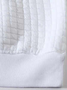 Macro shot of white waffle weave fabric texture with ribbed hem detail for men's sweatshirt
