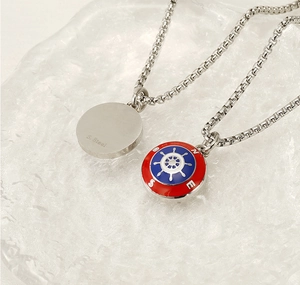 Detailed close-up of nautical anchor compass pendant with red and blue enamel finish