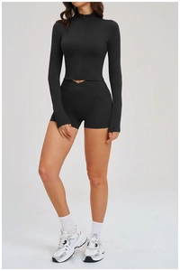Detail of black long sleeve zip top and cross-waist shorts for fitness workouts