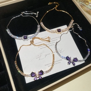 Détail de quatre bracelets papillon en zircon violet avec cordons de serrage réglables