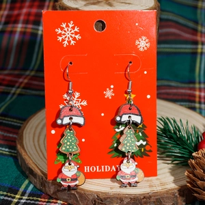 Orecchini natalizi in legno con Babbo Natale e albero su un cartoncino regalo rosso