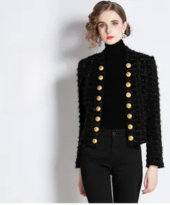Detail of tweed texture and embossed gold metal buttons on a black women cardigan