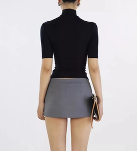 Rear view of a grey minimalist A-line mini skirt with a black high-neck top for women