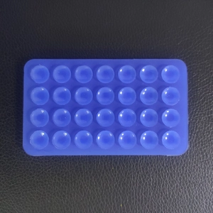 Detail view of a blue 28-suction cup rectangular silicone mat for non-slip mobile phone grip