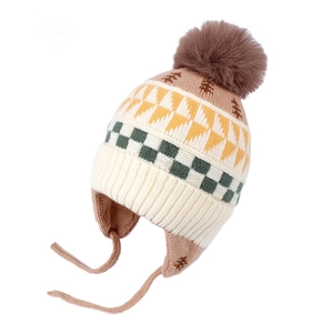 Beige knit earflap hat for kids featuring green checkers, yellow triangles and brown pompom