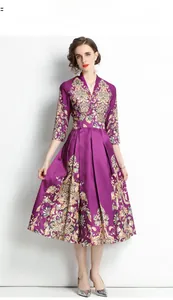 Detail of elegant V-neck purple vintage print dress with three-quarter sleeves and pleated hem
