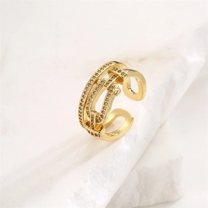 Macro detail of gold-plated multi-layer evil eye ring with pavé zircons on marble base