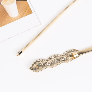 Detail of leaf-shaped gold metal buckle on an elastic spring waist belt for women
