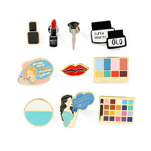 Set of 9 creative makeup enamel pins featuring lipstick, brushes, and colorful palettes