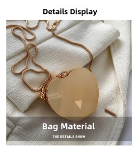 Detailed macro shot of the golden heart-shaped metal bag with a refined snake chain strap