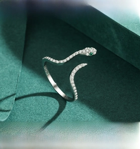 Macro view of S925 sterling silver snake ring with pavé zircons and green gem eyes
