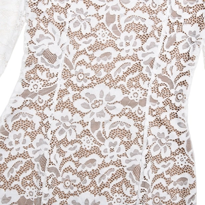 Close-up of white floral lace fabric with nude lining and high-quality stitching details