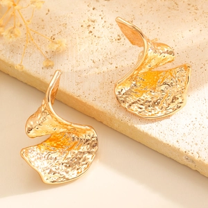 Hammered gold irregular geometric metal earrings on elegant stone display