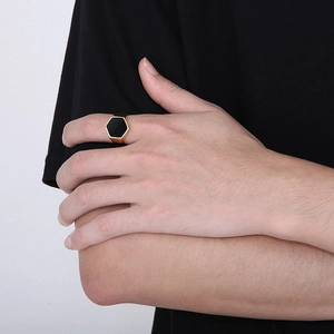 Minimalist gold hexagon signet ring with black enamel inlay on a model's hand