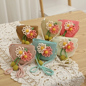 Detailed macro view of woven straw shoulder bags with floral accents in multiple colors