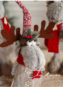 Detailed close-up of a Christmas reindeer plush toy with red knitted scarf and grey faux fur