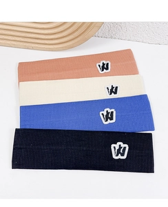 Flat lay of four colorful knitted sports headbands in orange beige blue and black