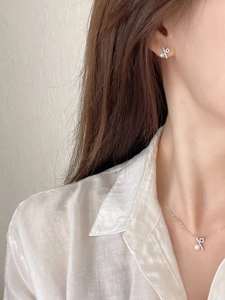 Close-up of S925 sterling silver necklace and earrings with pearls on a female model